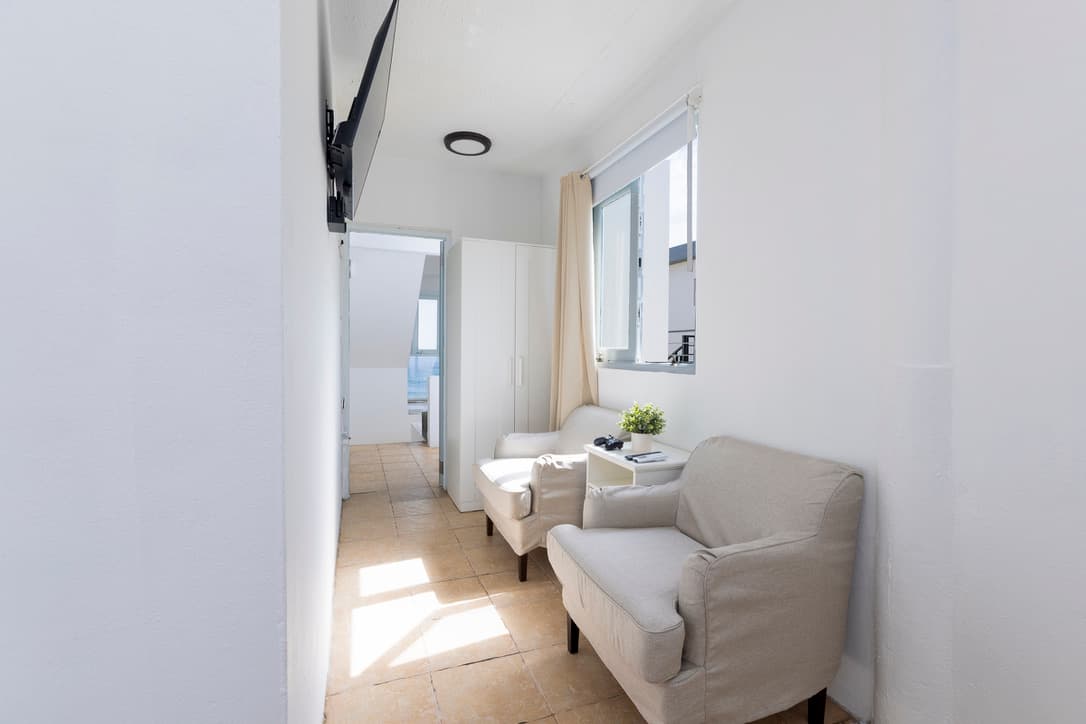 Private game lounge with two chairs and wall-mounted TV beside Bedroom 4